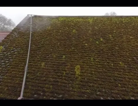 Moss removal on a roof with power washer