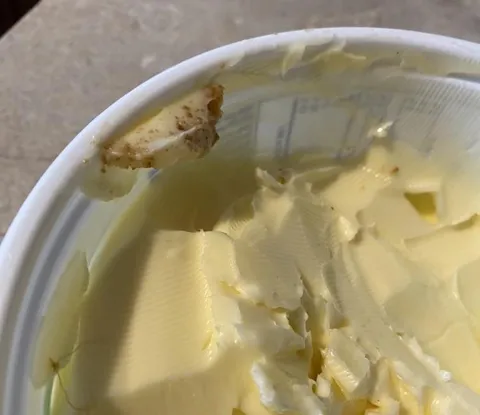 Husband scrapes his toast crumbs back into the butter container