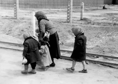 An elderly woman and 3 children walking to the gas chambers in Auschwitz 1944.