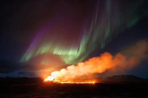 🔥 Aurora borealis over an erupting volcano 🔥