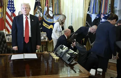 Trump looks on after a man fainted during an announcement in the Oval Office
