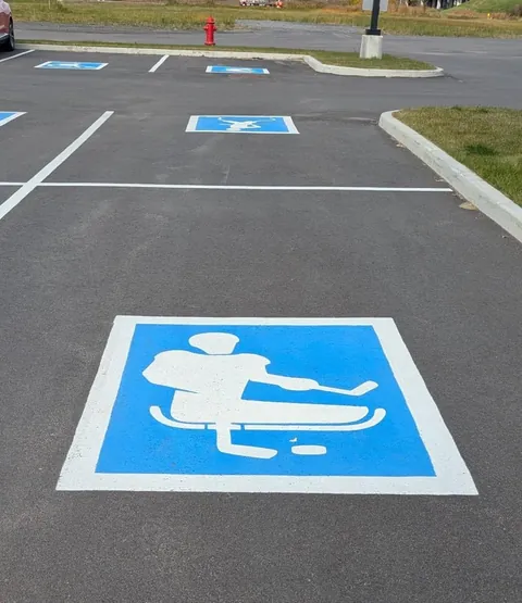 Spotted creative handicap parking signs depicting different parasports outside a sporting goods store