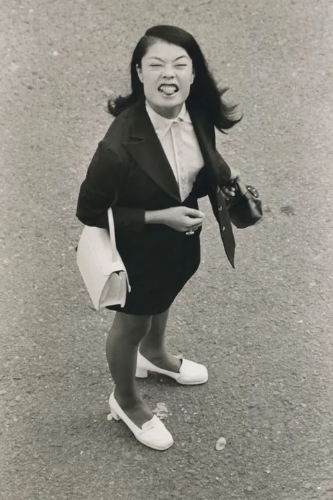 In 1974, Masahisa Fukase photographed his wife, Yōko Wanibe, every morning from the window of their apartment in Tokyo as she left for work.