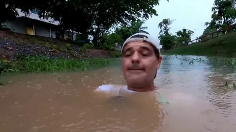 Man greeted by Otter pup in the water