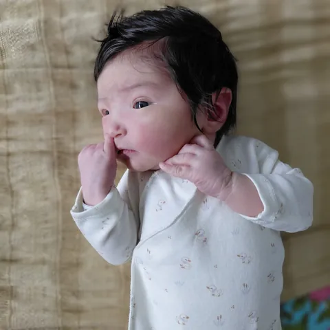 I was not aware newborn babies could have this much hair. She looks like a manga character.