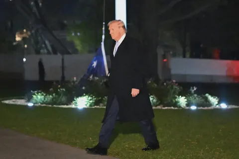 President Trump walking past the flag at the Whitehouse which has fallen to the ground