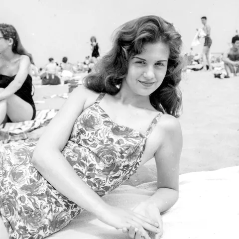 Lady smiles for the camere at the beach, 1940s