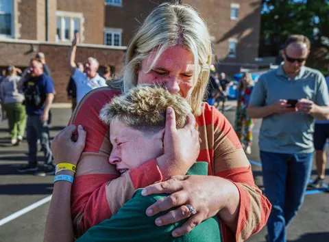 OC: A mom hugs her son outside a Minneapolis school and church. 2 children killed in a shooting.