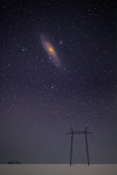 I took a picture of the Andromeda galaxy and power lines (actual scale, stack photo)