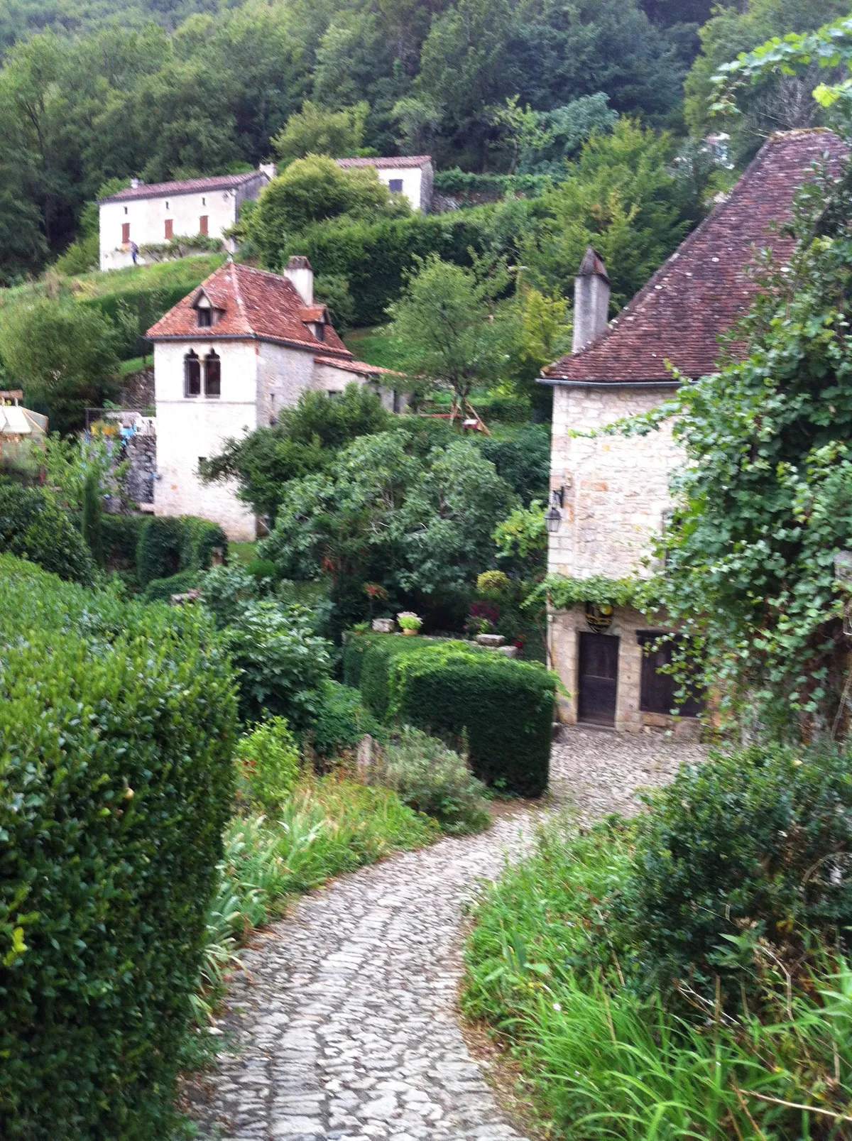 Surrounded by lush green and worn stone in this French village [OC]