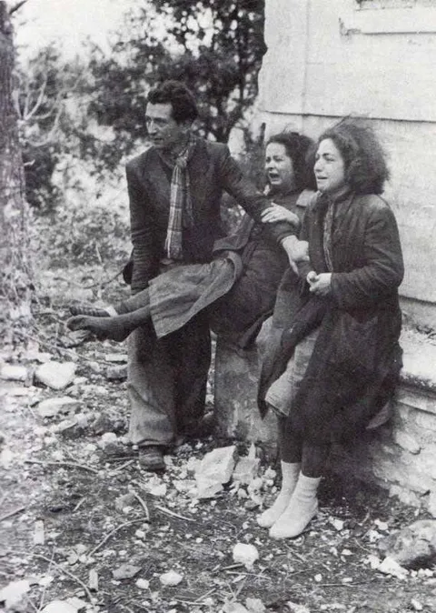 Italian man stands with two Italian women who have been r**ed by the C.E.F. during the battle of Montecassino in the event known as the "Marocchinate"
